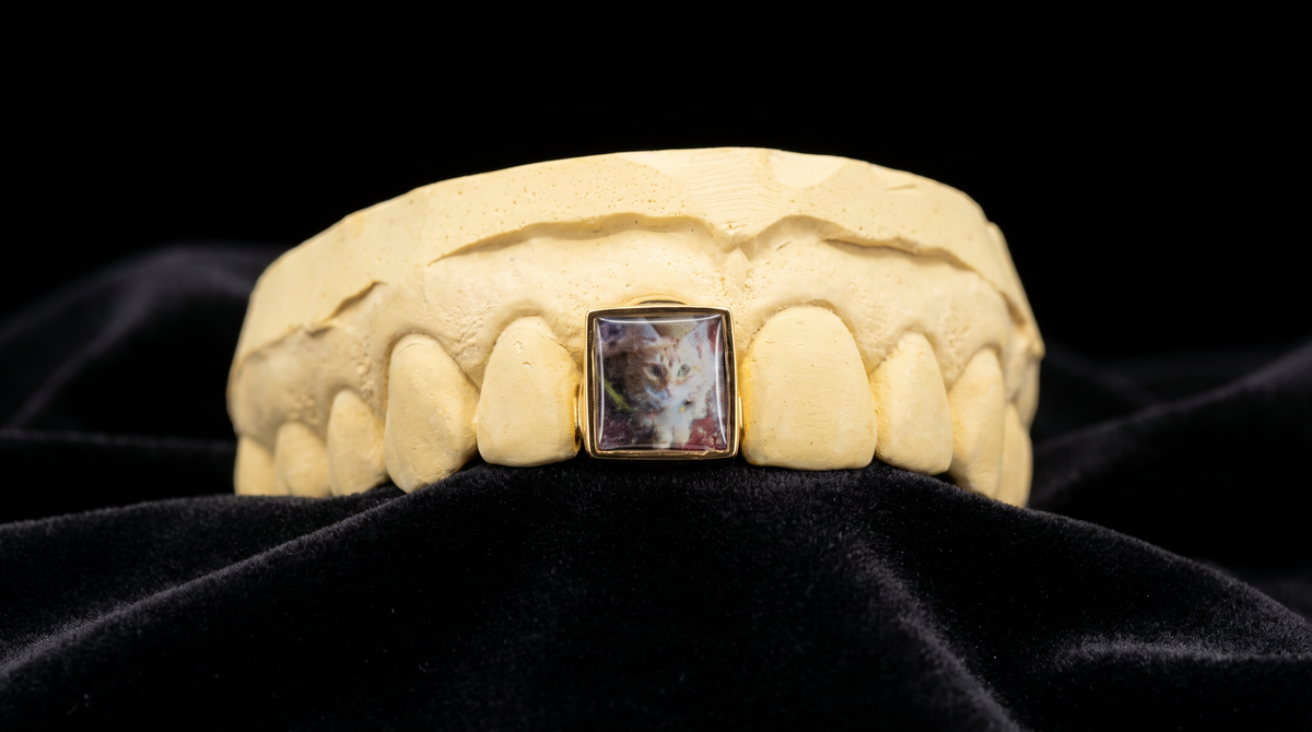 Picture grillz tooth with a photo set in a gold bezel on dental mold